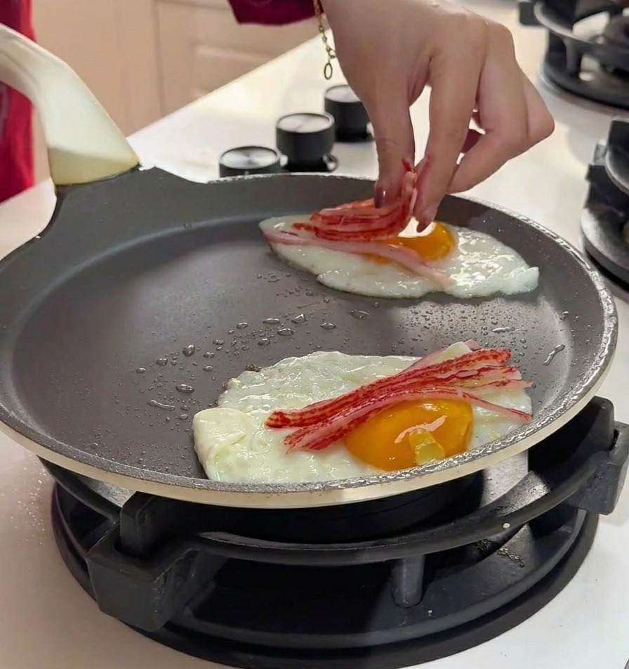 Colocando tiras finas de palitos de cangrejo sobre los huevos en la sartén.