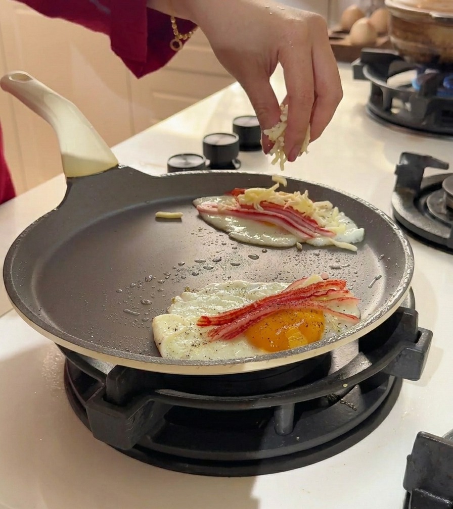 Queso mozzarella rallado espolvoreado sobre los huevos y el cangrejo.