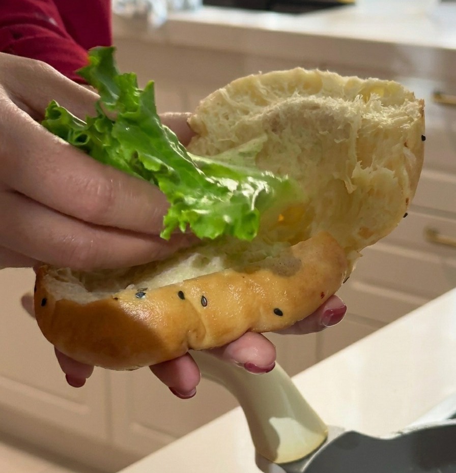 Colocando una hoja de lechuga rizada dentro del pan de pancake.