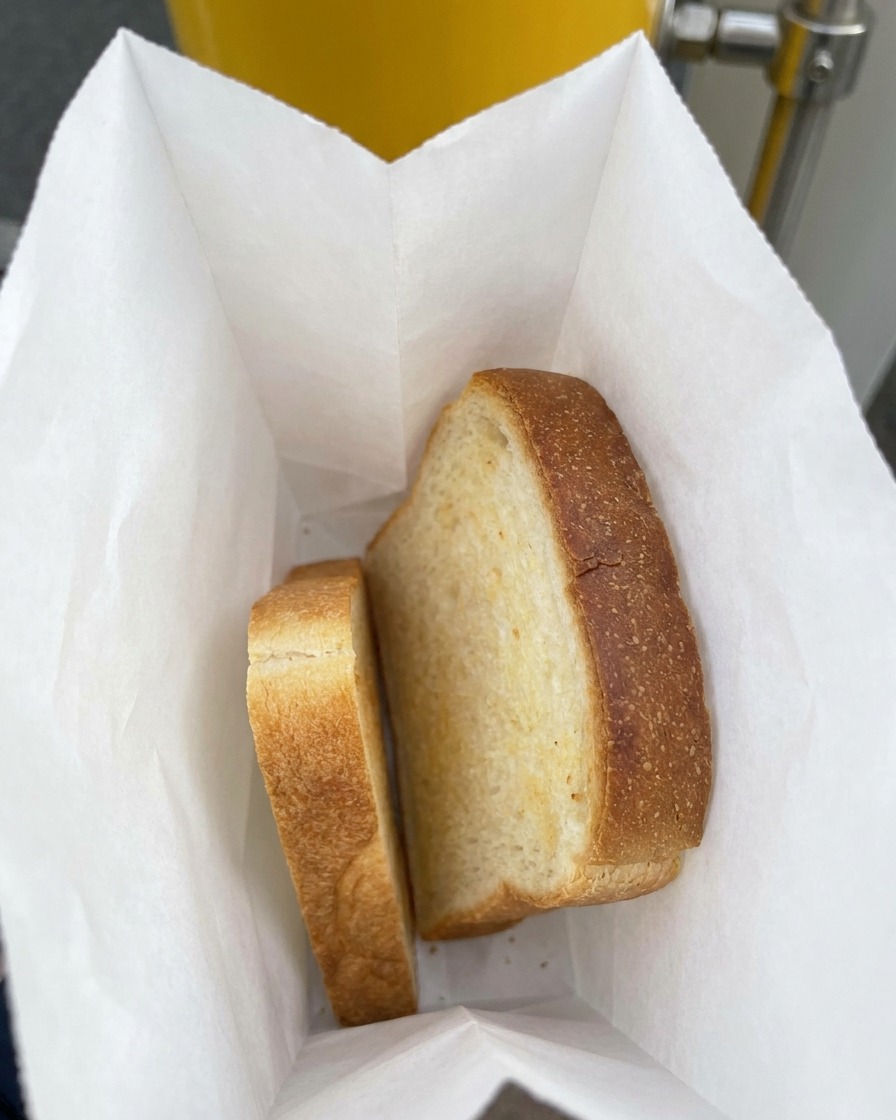 Dos rebanadas gruesas de pan de molde blanco dentro de una bolsa de plástico.