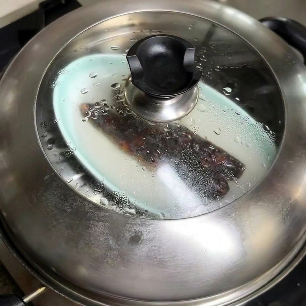 Salchicha china al vapor cortándose en rodajas sobre una tabla de madera.