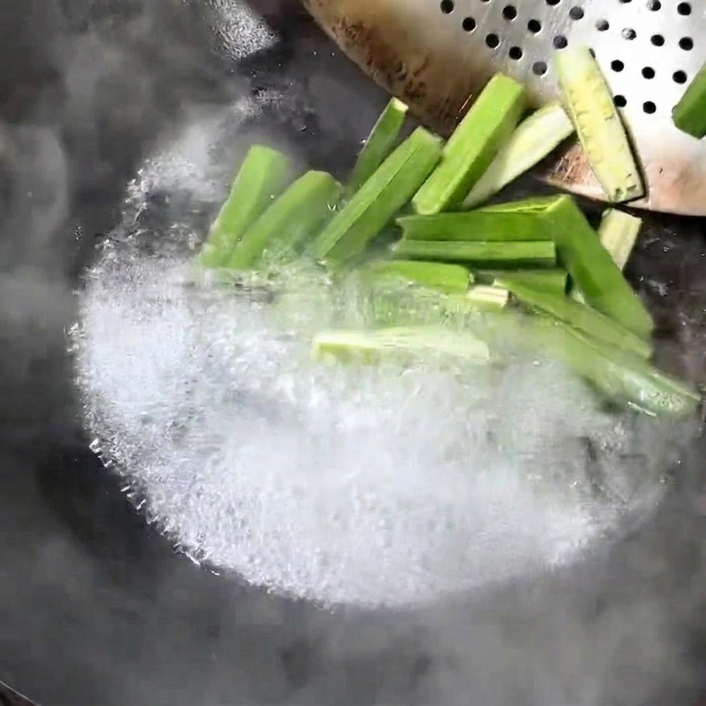 Trozos de okra fresca hirviendo en un wok.