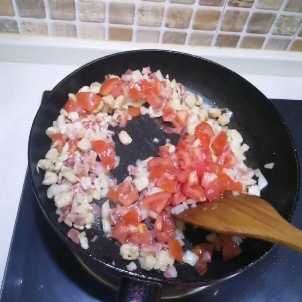 Tomates troceados añadidos a la sartén con la carne y la cebolla.