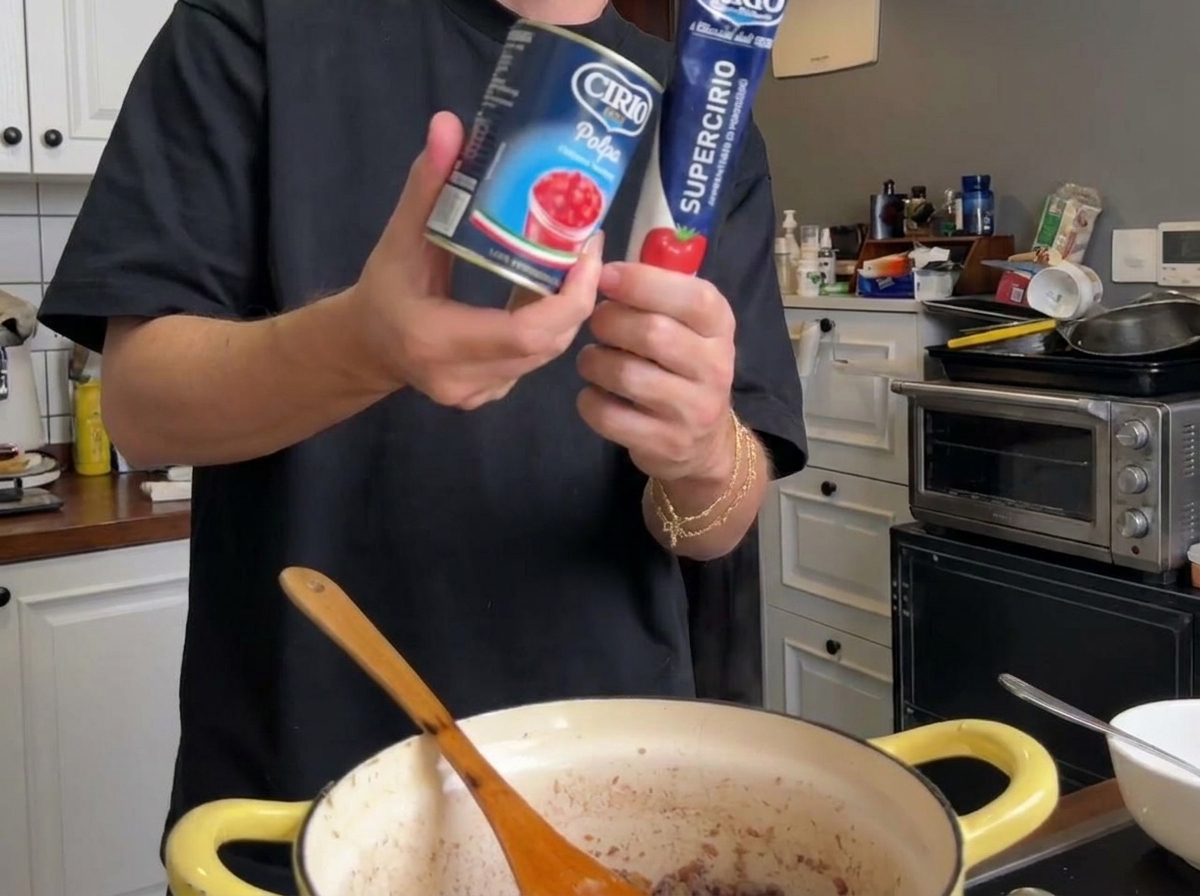 Puré de tomate en conserva y un tubo de concentrado de tomate sobre la olla de cocción.