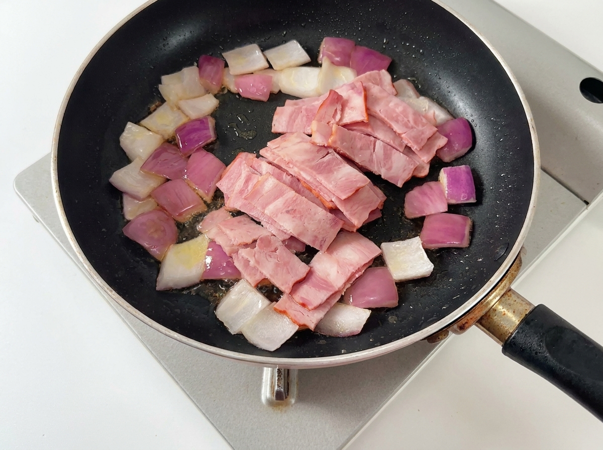 Cebolla, tocino y champiñones cocinándose juntos en la sartén.