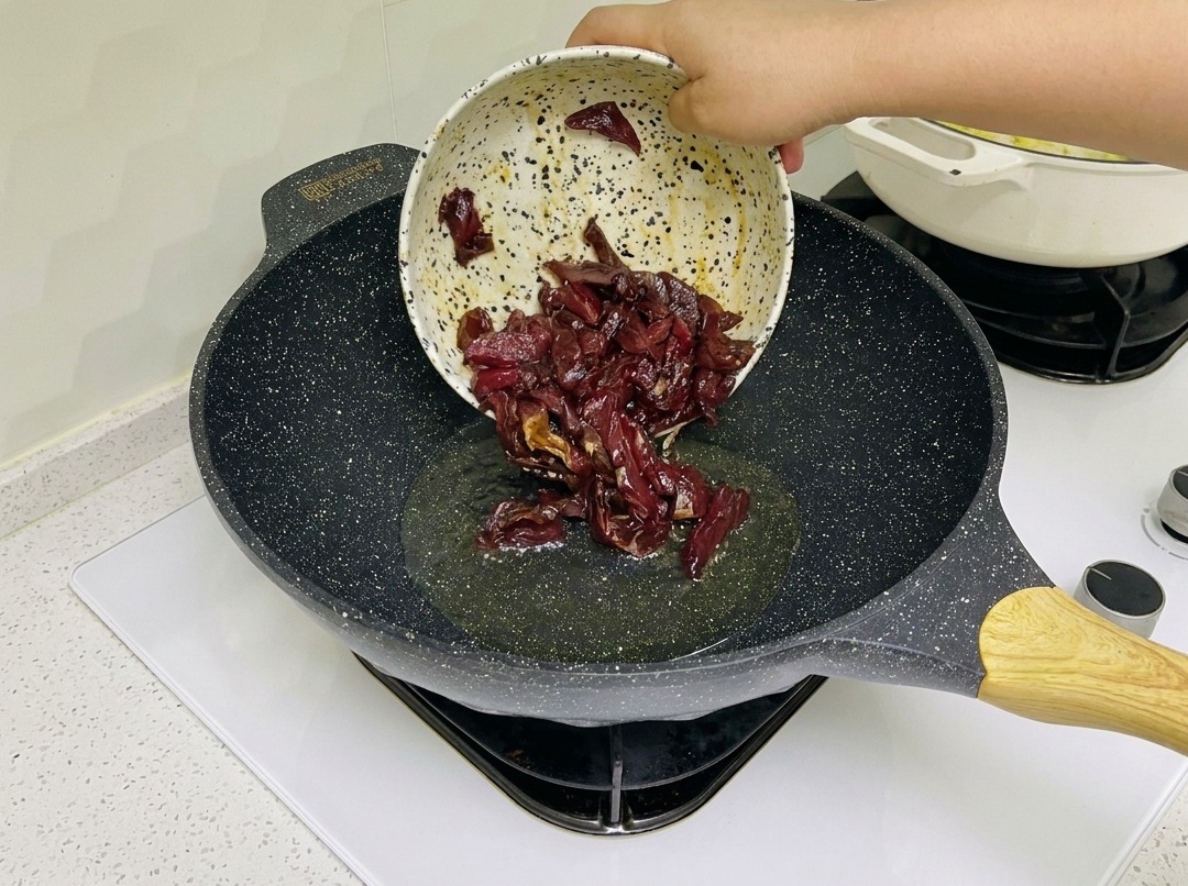 Tiras de ternera marinada dorándose en un wok caliente.
