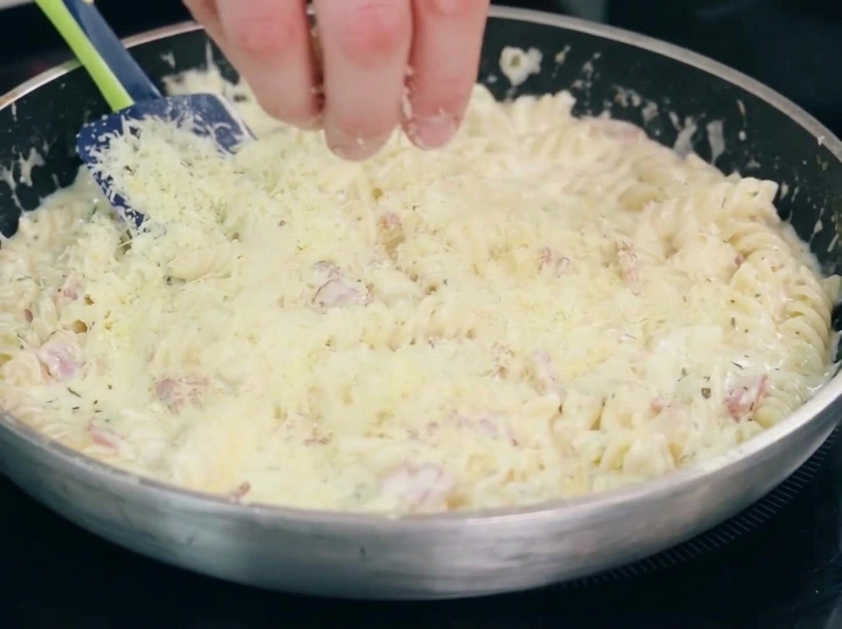 Cebollas y ajo cocinándose con el bacon en una sartén.