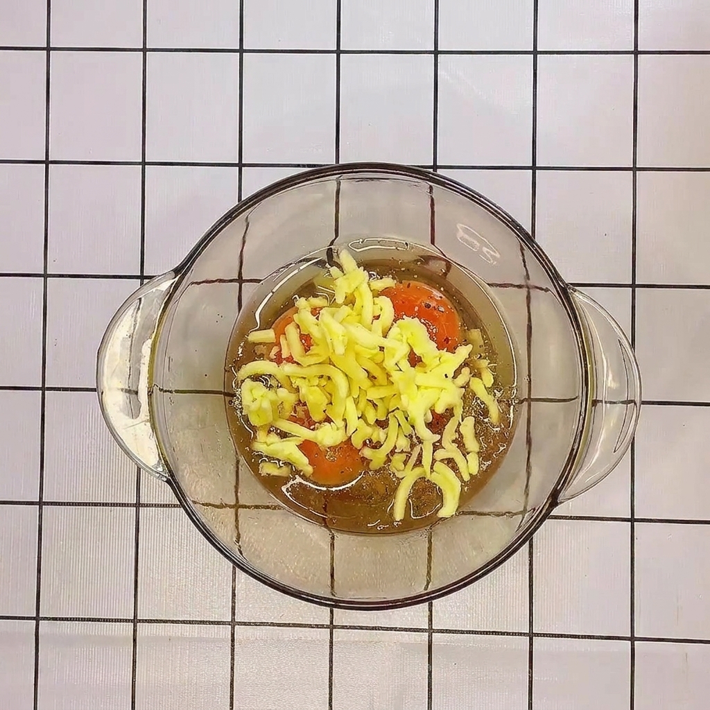 Primer plano de los huevos y el queso siendo batidos juntos en un tazón de vidrio.
