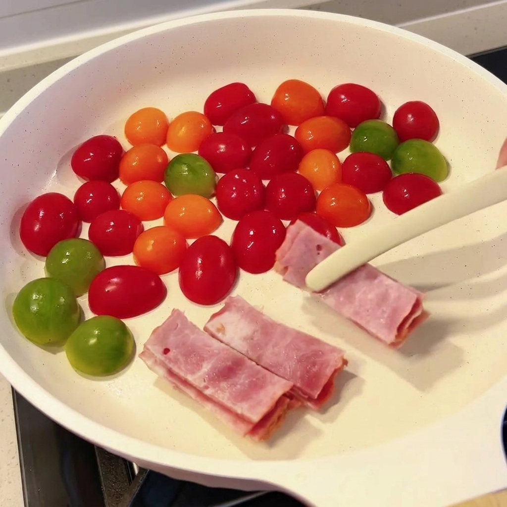 Lonchas de bacon crudo siendo colocadas en la sartén con los tomates cherry usando unas pinzas.