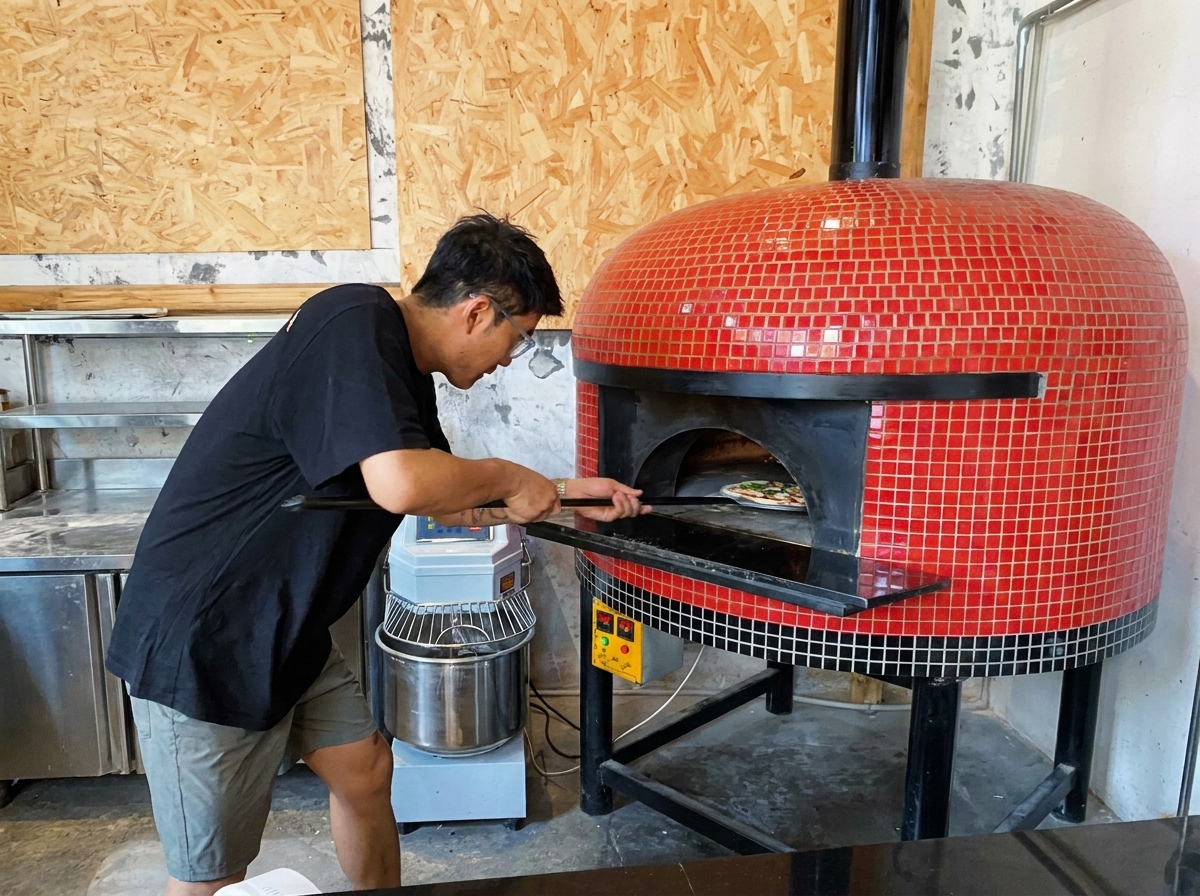 Una pizza siendo deslizada hacia el interior de un horno de leña con una pala.