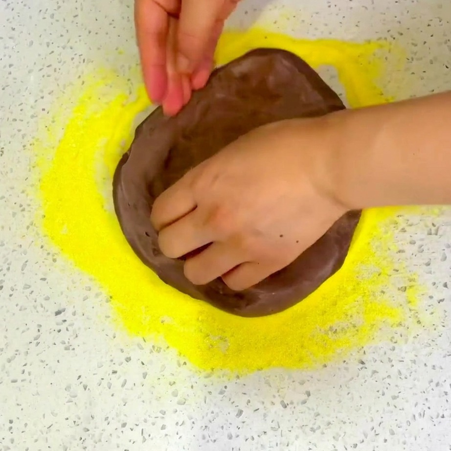 Pimienta negra recién molida y hierbas secas siendo espolvoreadas sobre la pizza cubierta de queso.