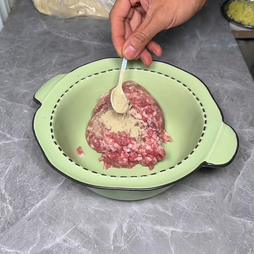 Carne molida en un bol siendo sazonada con especias y salsas.