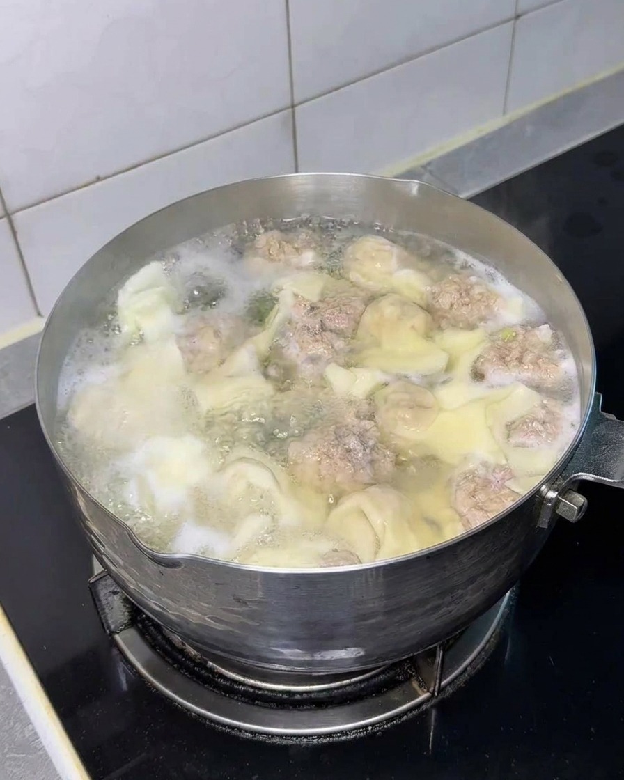 Bloque de fideos instantáneos sumergiéndose en la olla.