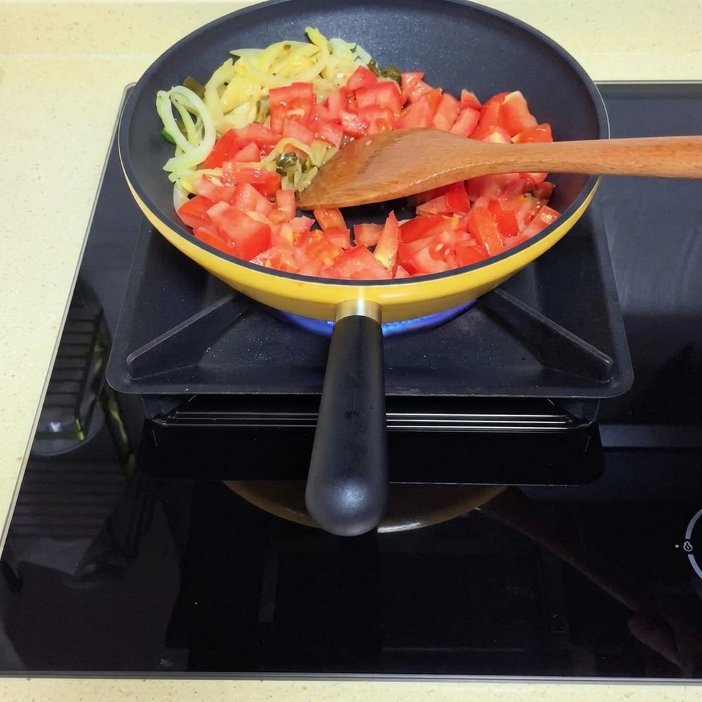 Tomates cociéndose hasta formar una salsa suave en la sartén.