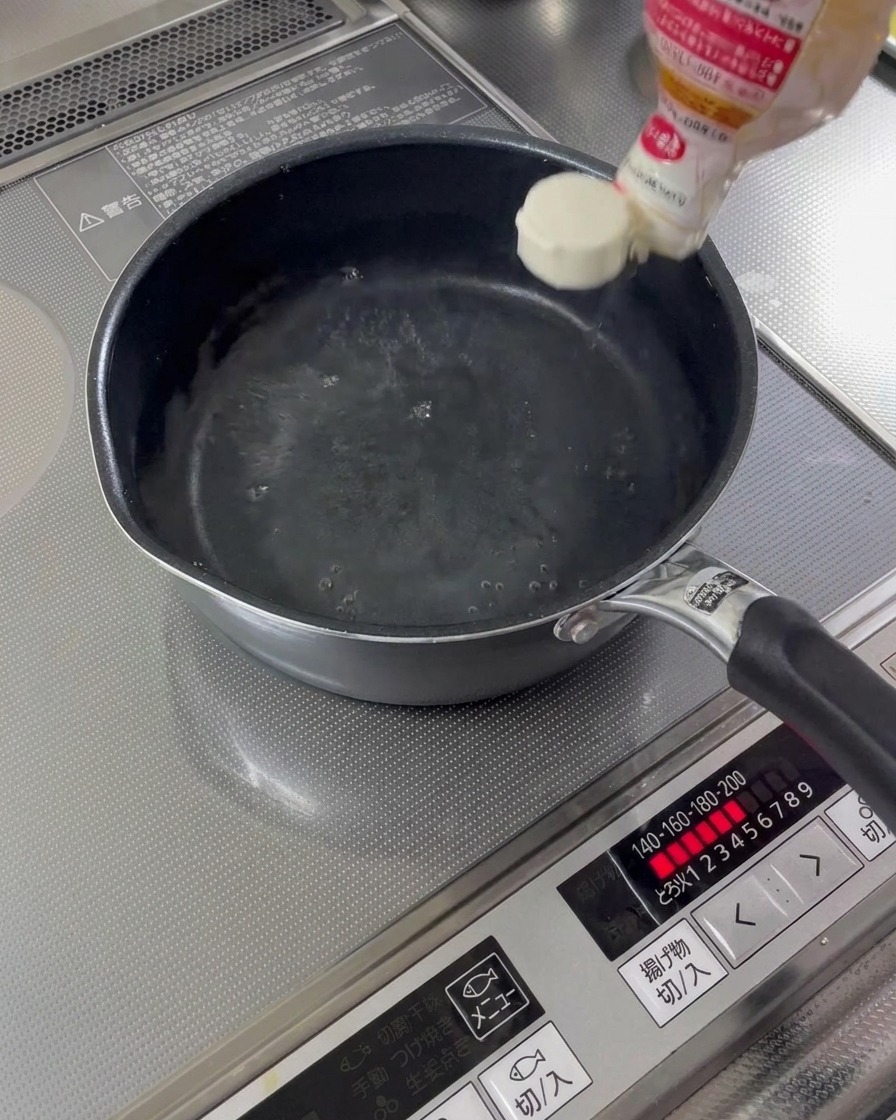 Sake de cocina y mirin vertiéndose en un cazo con agua.