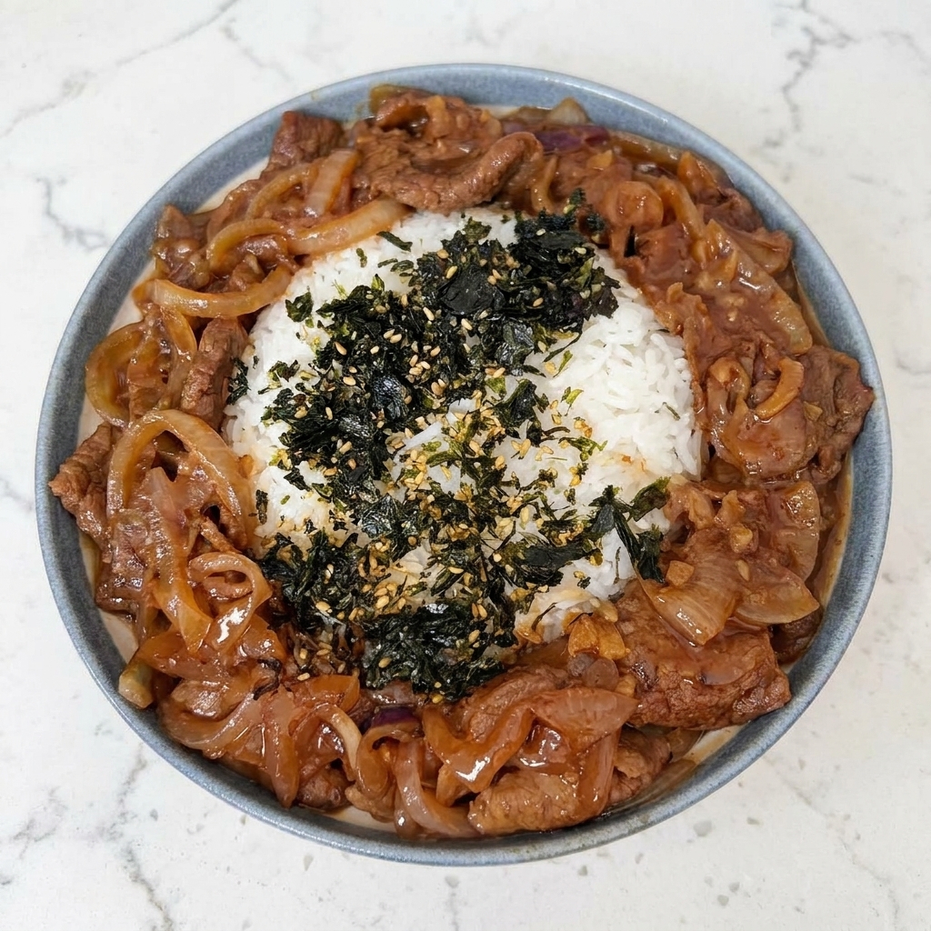 Primer plano de un tazón de arroz decorado con una pizca de algas nori trituradas y semillas de sésamo tostadas.
