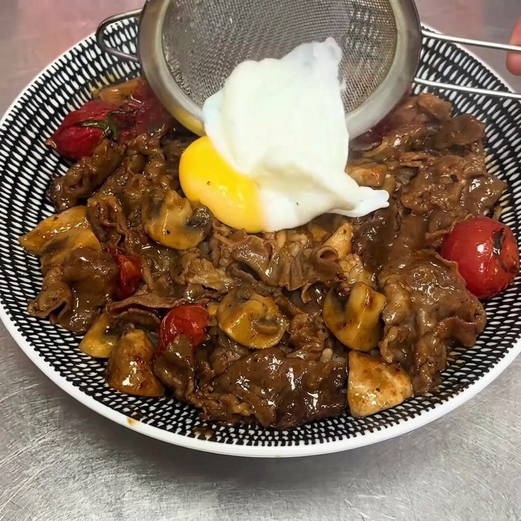 Un huevo a baja temperatura siendo colocado sobre el bowl con cuidado.