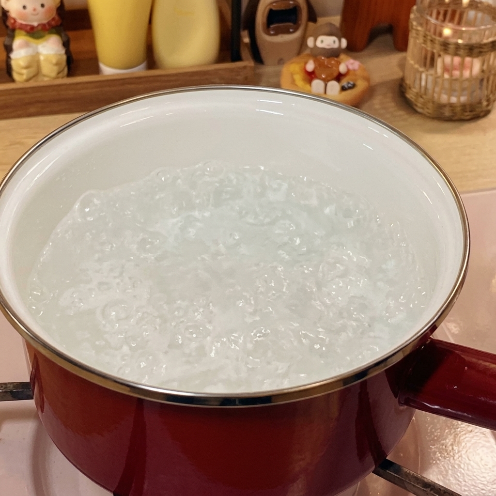 Rollitos de ternera congelada sumergidos en agua hirviendo en una olla roja.