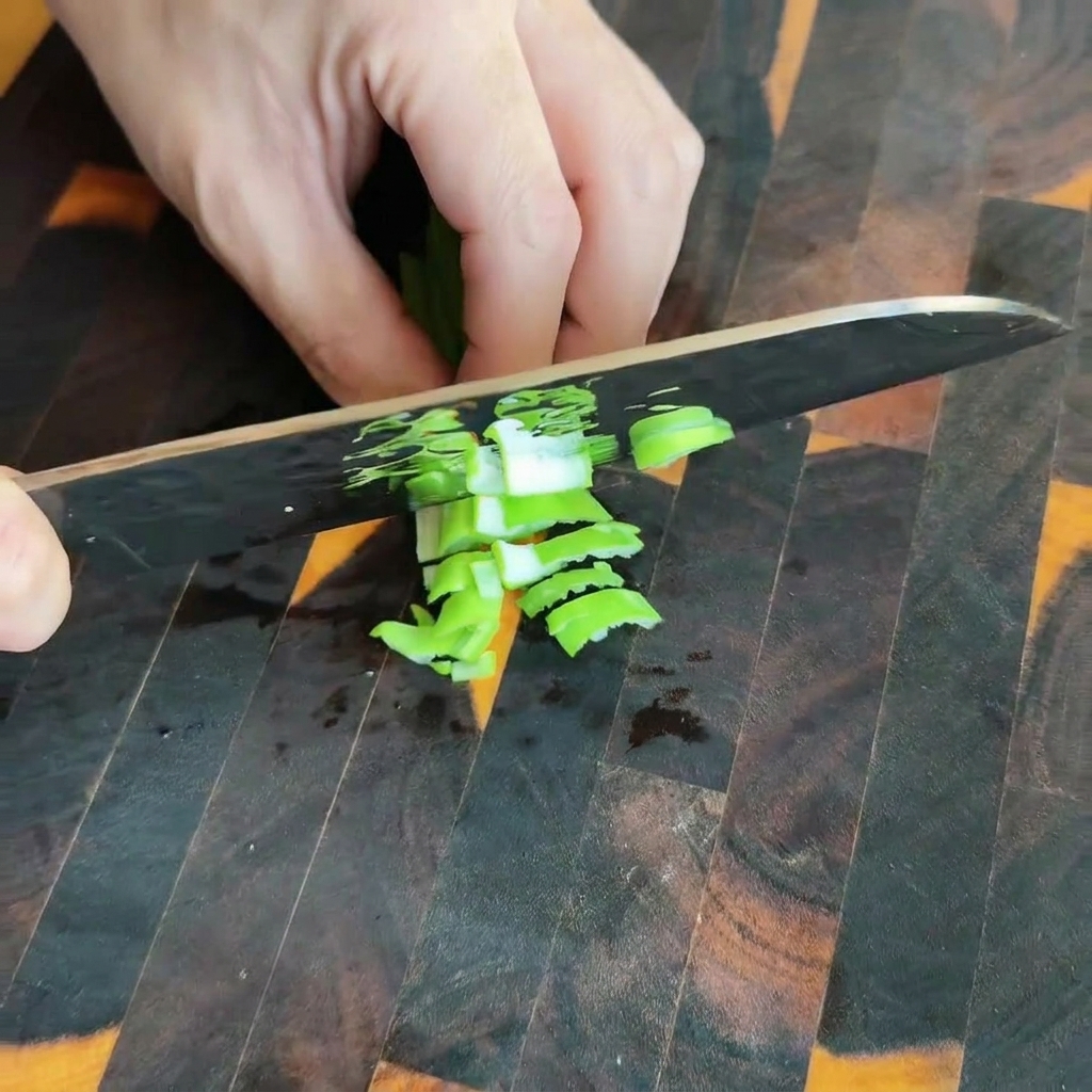 Mostaza verde encurtida siendo picada sobre una tabla de cortar de madera.