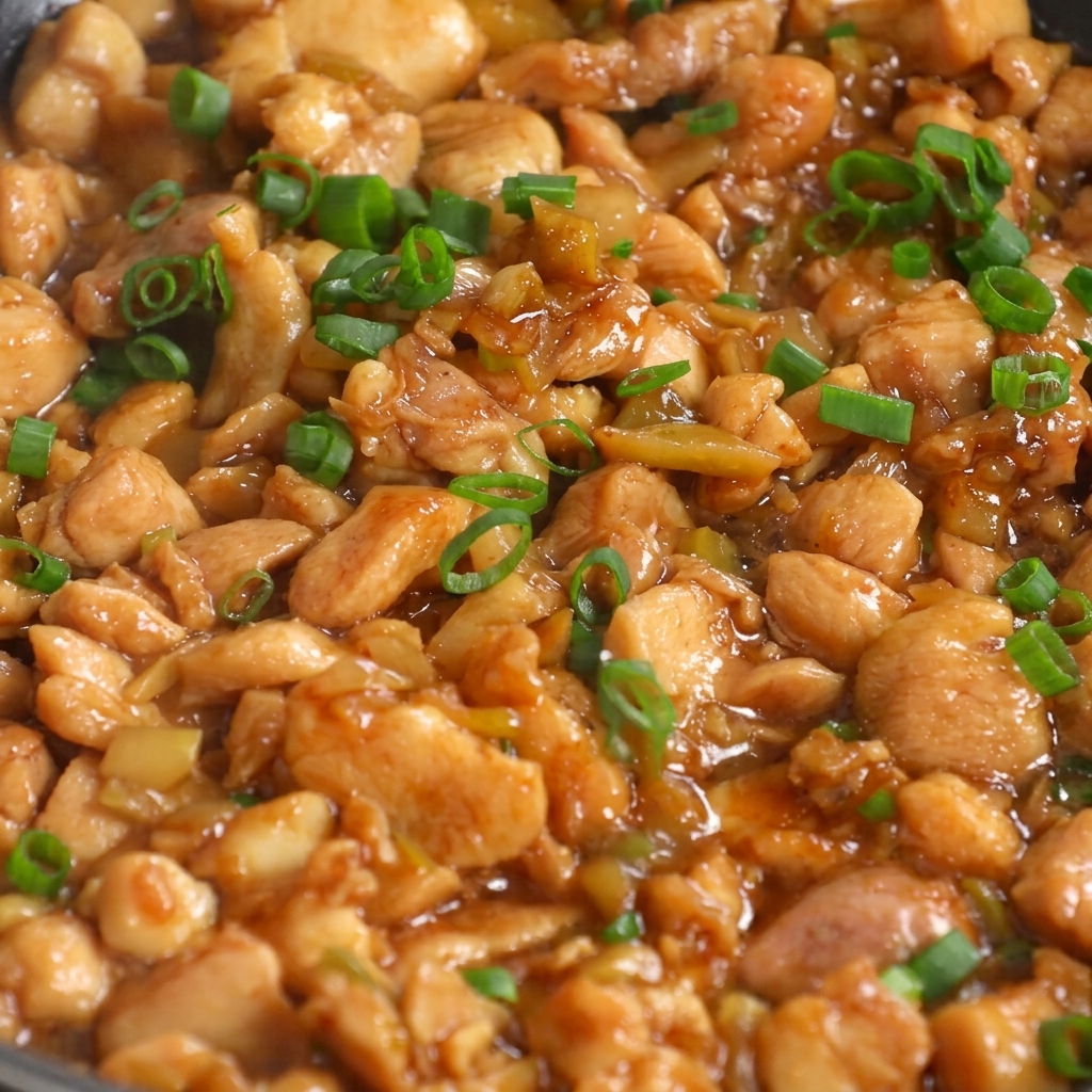 Salteado de pollo y encurtidos terminado, adornado con cebolletas recién picadas en una sartén.