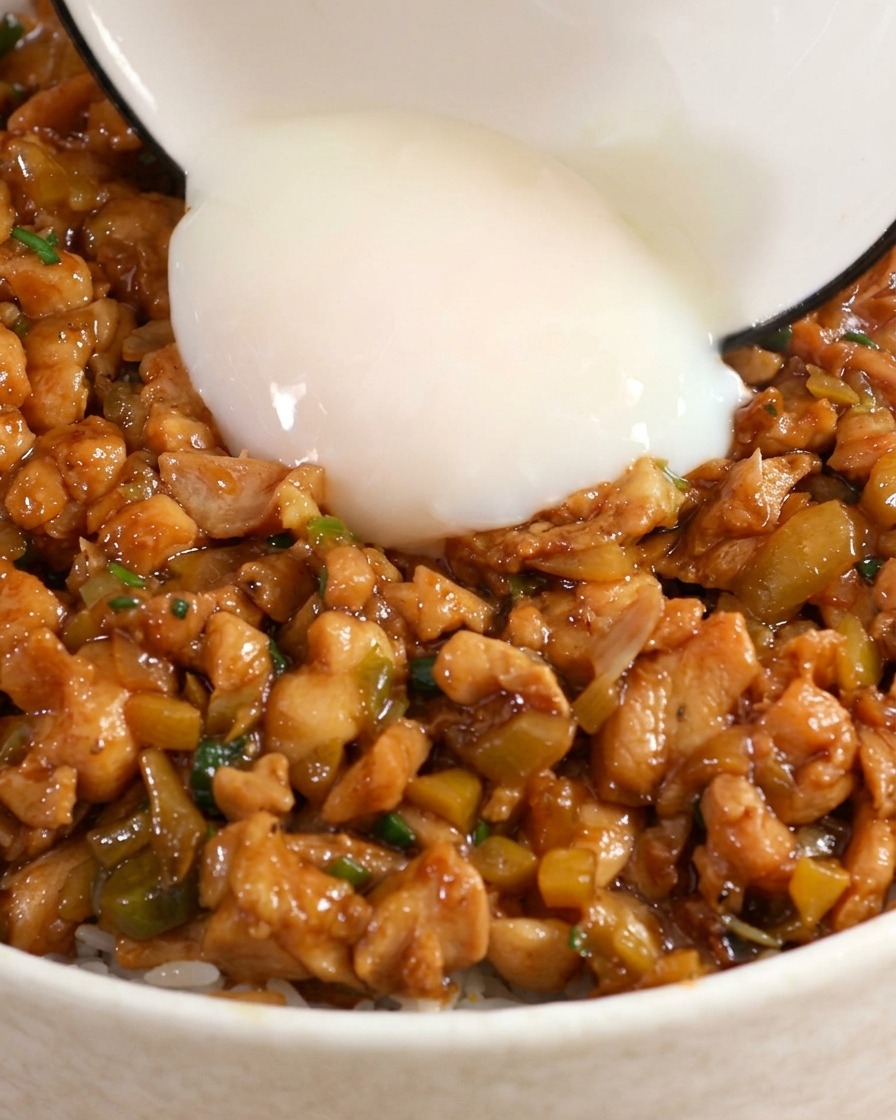 Un huevo onsen pasado por agua añadido al centro de un tazón de pollo y arroz.