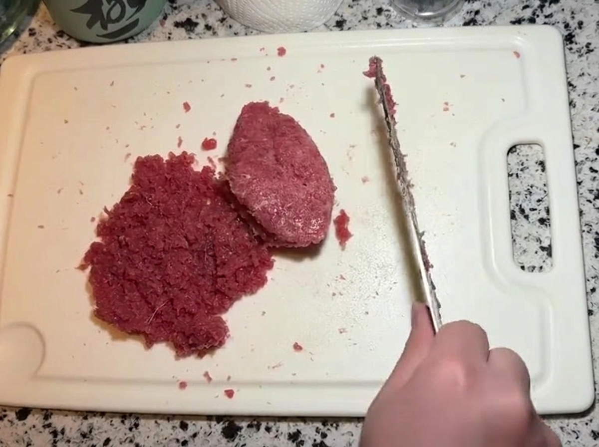 Un cuchillo integrando la pasta de mayonesa con el resto del atún picado.