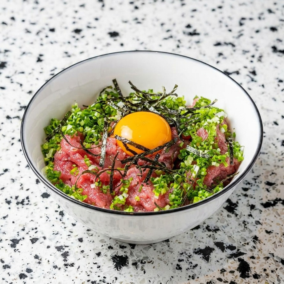 Bol con atún, arroz, cebolleta, alga nori y una yema cruda en el centro.