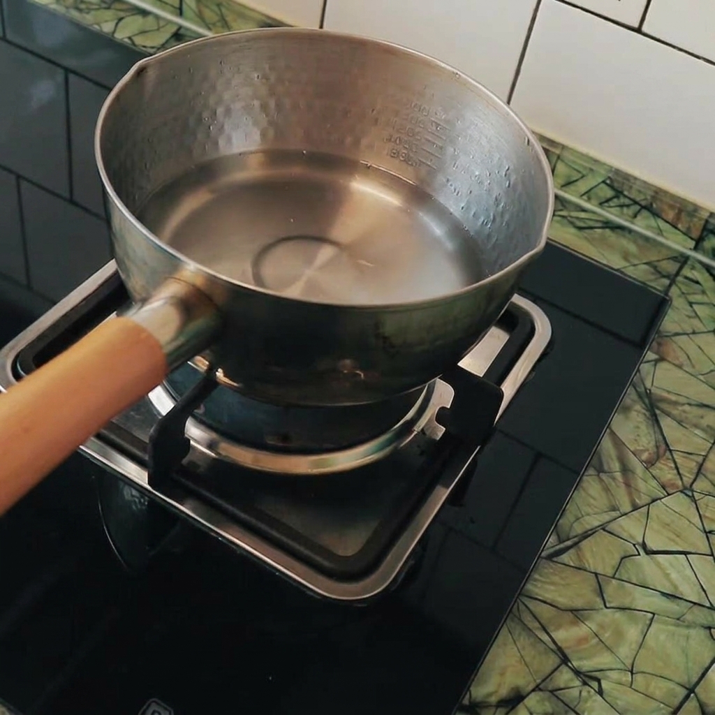 Cubos de tofu siendo añadidos a una olla con agua hirviendo.