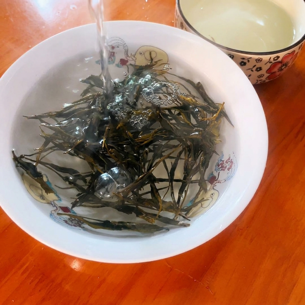 Agua hirviendo vertiéndose sobre hojas de té verde seco en un pequeño cuenco decorativo.