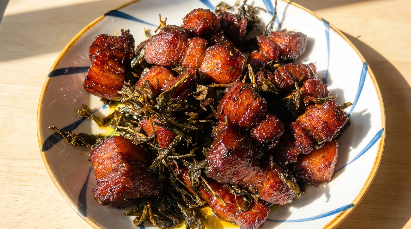 Brillantes cubos de panceta de cerdo caramelizada mezclados con hojas de té verde crujientes.