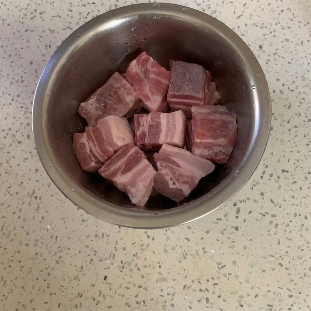 Cubos de panceta en un bol de metal ligeramente cubiertos de azúcar.
