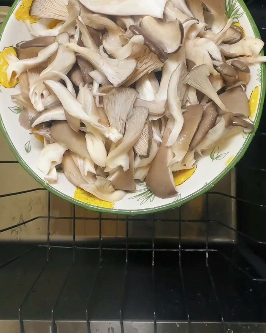 Agua vertiéndose en un bol que contiene setas ostra saladas.