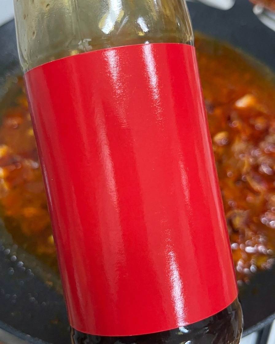 Salsa de ostras exprimiéndose sobre el caldo rojizo.