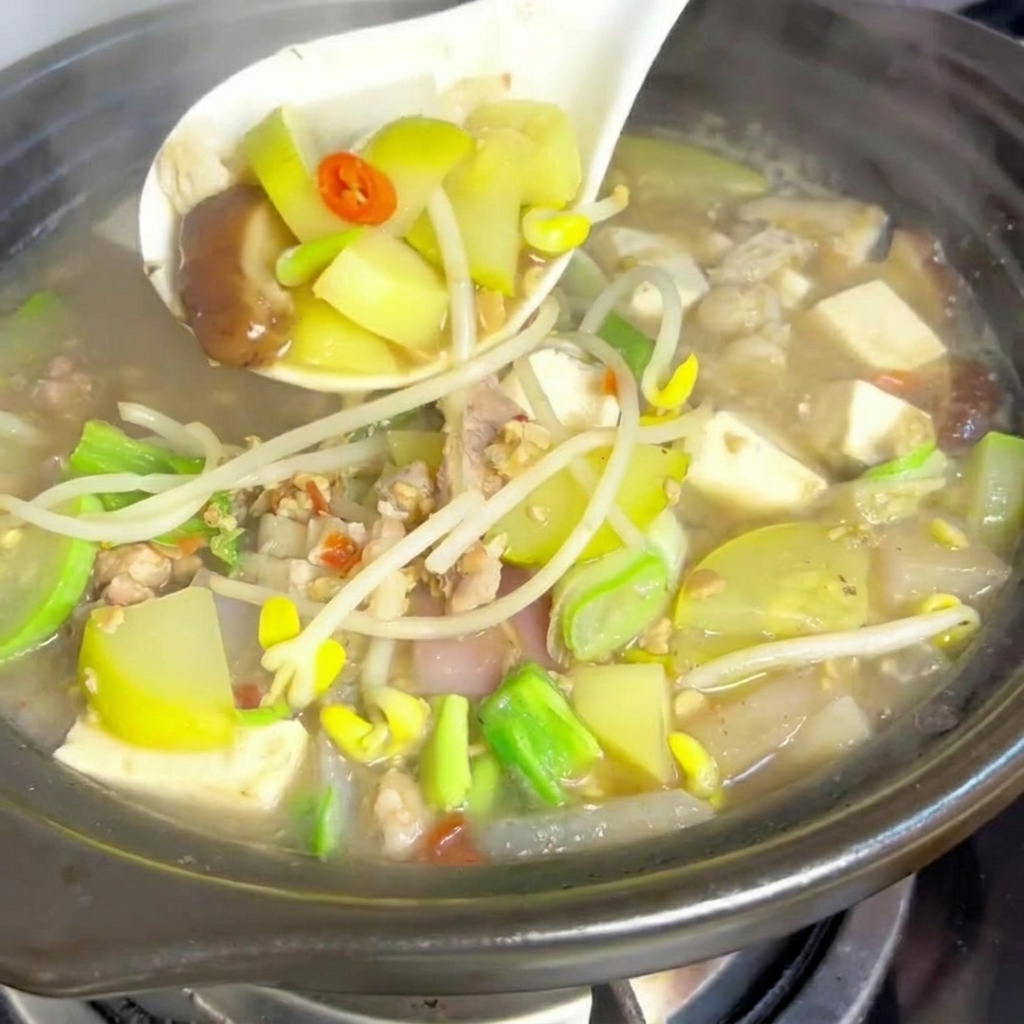 Rodajas de panceta de cerdo dorándose en una olla de barro caliente.