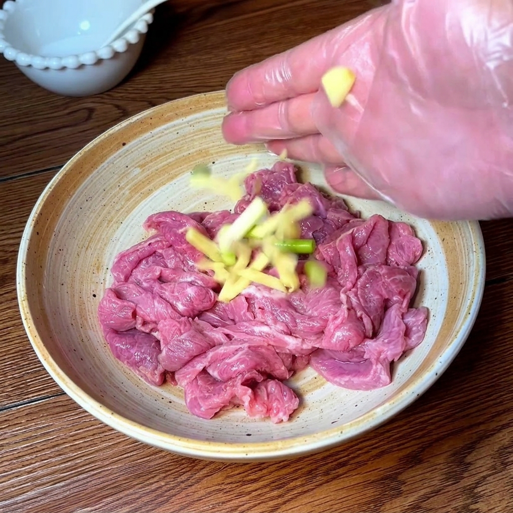 Mano con guante sazonando y masajeando la ternera con los aromáticos y especias.