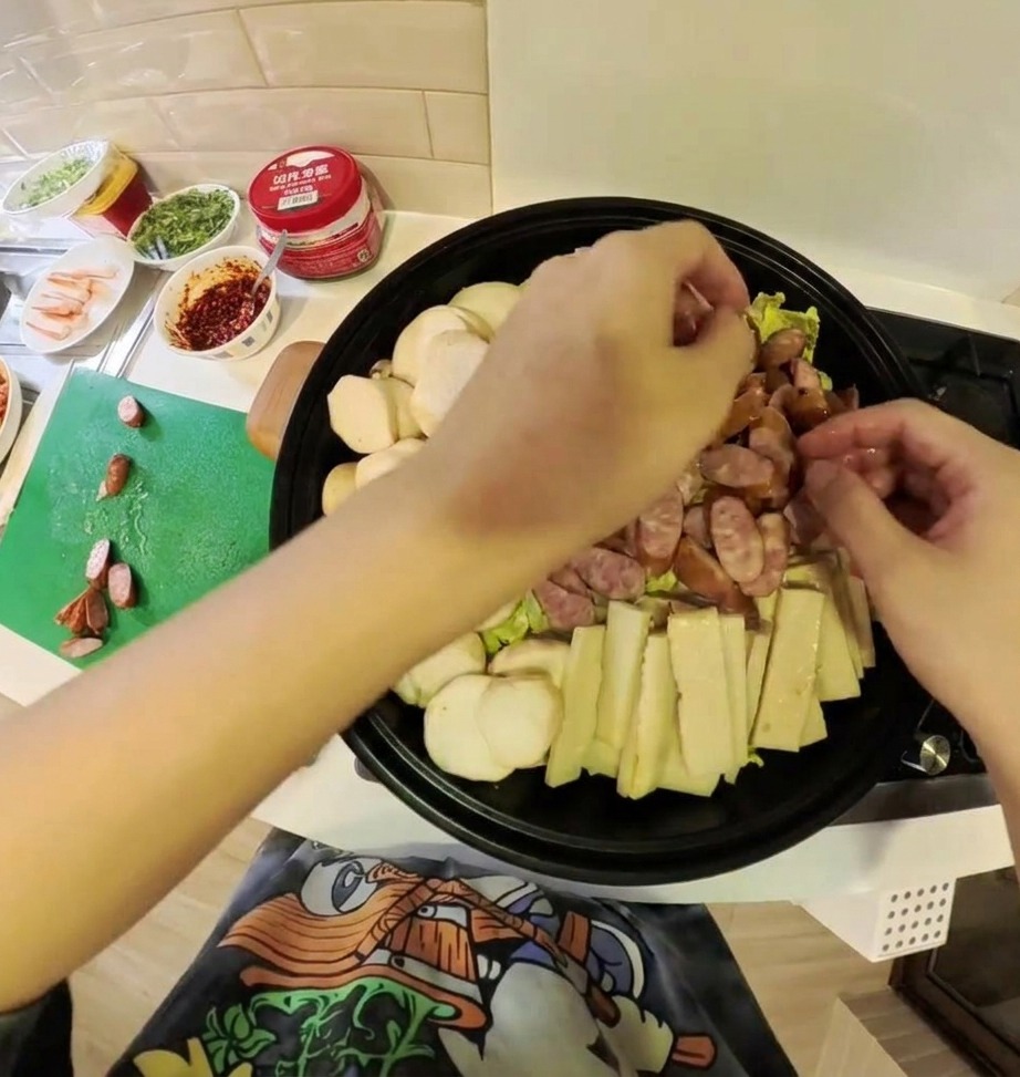 Una variedad de ingredientes preparados para el estofado, incluyendo kimchi, carne y verduras, colocados maravillosamente dentro de una olla poco profunda.