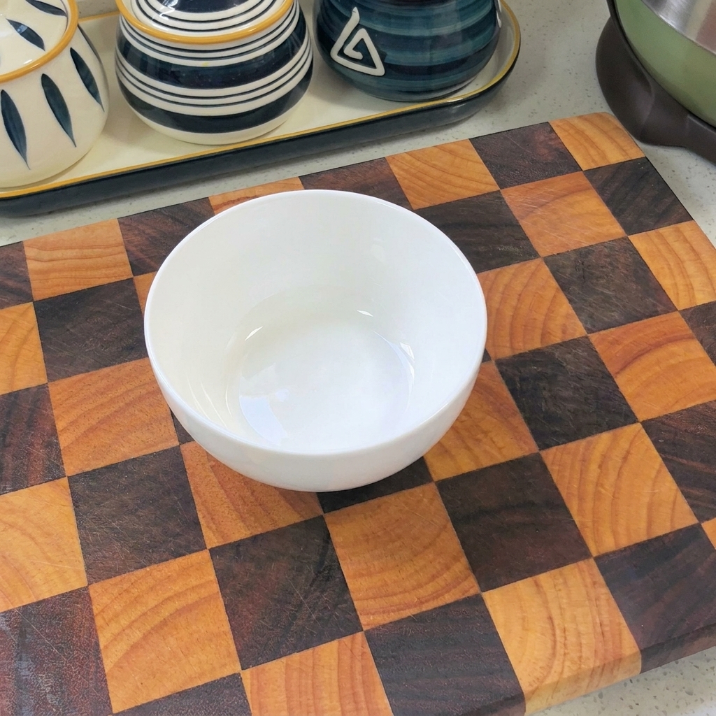 Primer plano de una mezcla de pasta de chile coreano, salsa de soja y sazonador de ramen en un bol blanco, lista para mezclar.