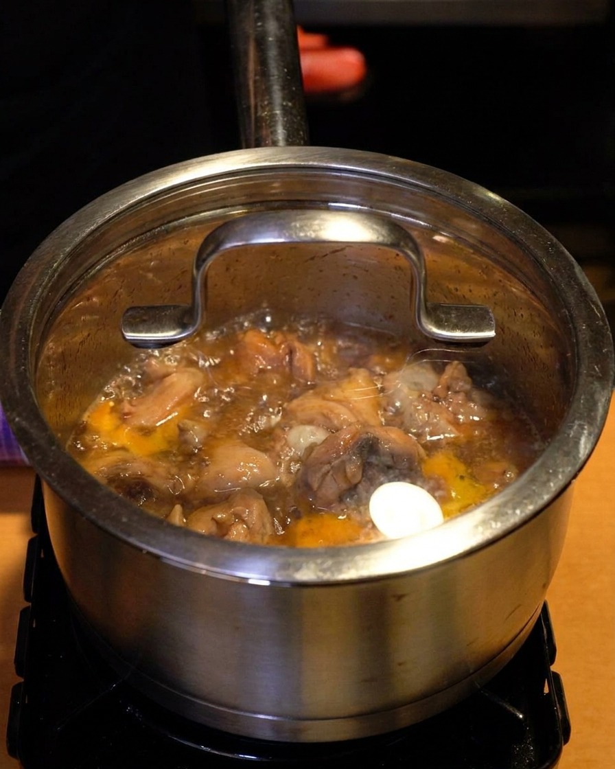 Una olla de acero inoxidable con tapa de cristal donde se aprecia el vapor y el líquido burbujeante.