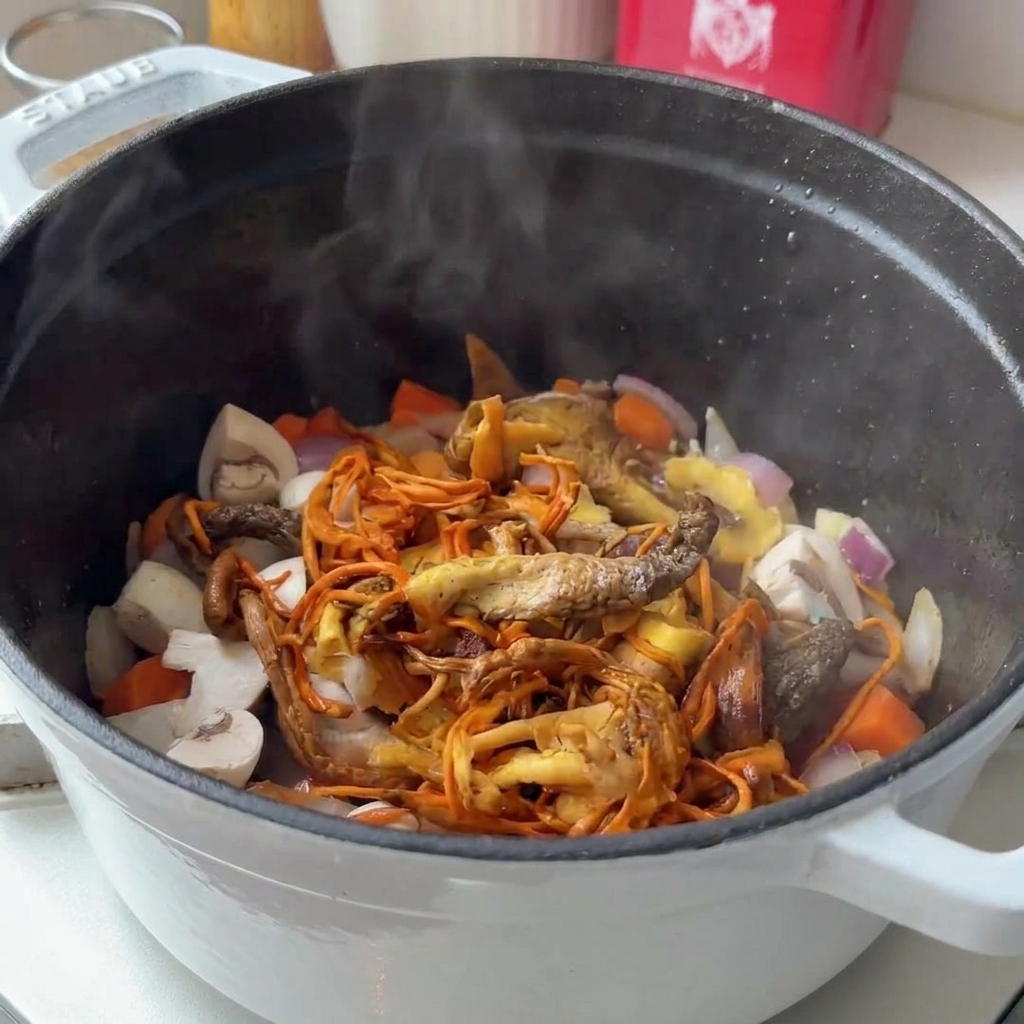 Variedad de setas frescas y rehidratadas siendo añadidas a una olla humeante con vegetales sofritos.