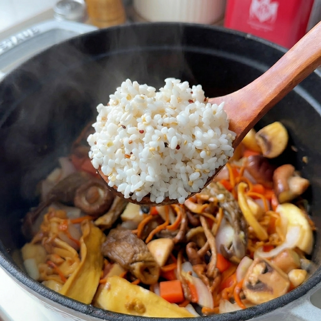 Cuchara de madera levantando una porción de arroz blanco mezclado con quinoa sobre una olla con setas y zanahoria.