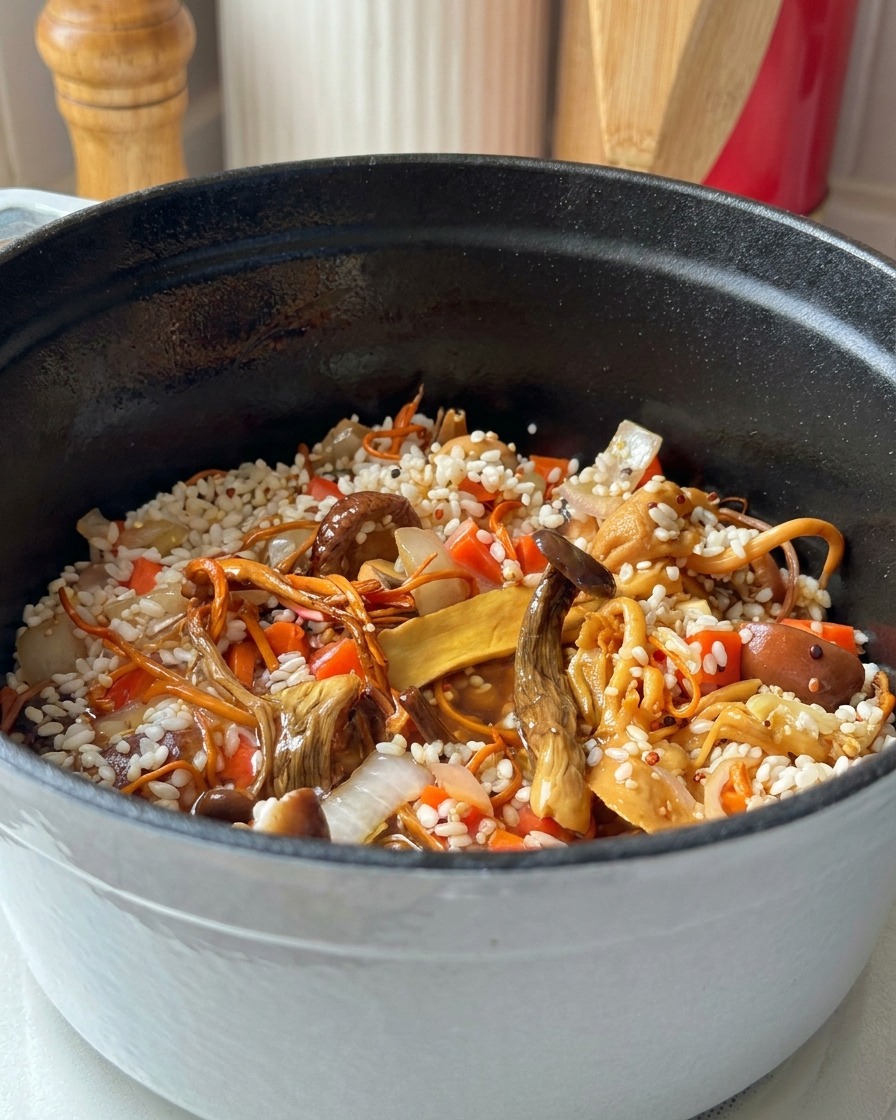 Agua vertiéndose en una olla de hierro con arroz, quinoa, zanahoria y varios tipos de setas.
