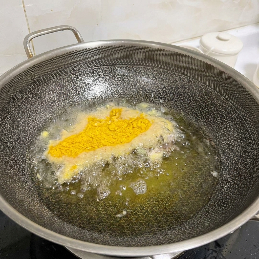 Filetes de pollo marinados cubiertos con pan rallado fríendose ligeramente en un wok caliente con aceite burbujeante.