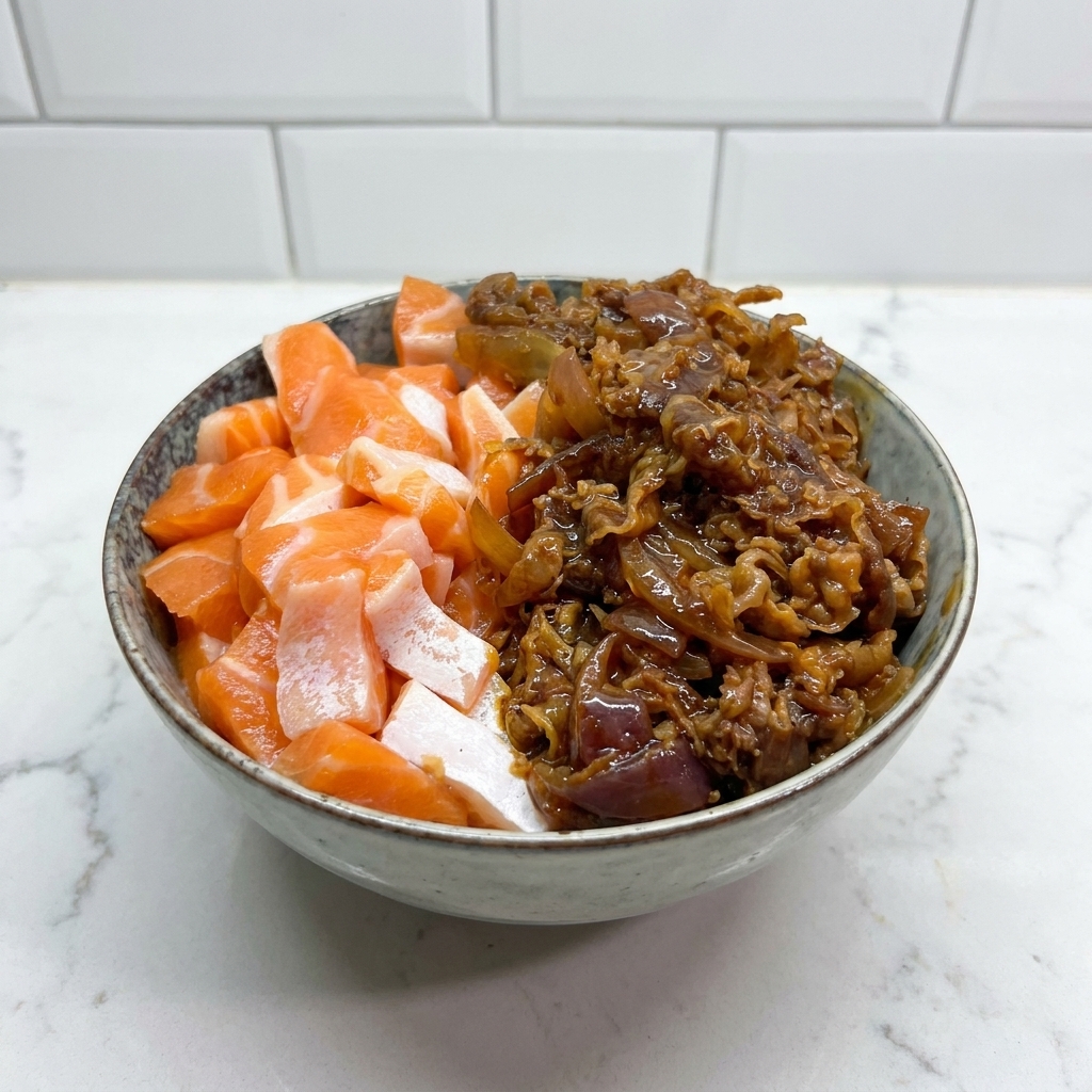 Bol de cerámica con salmón crudo a la izquierda y ternera salteada con salsa a la derecha.