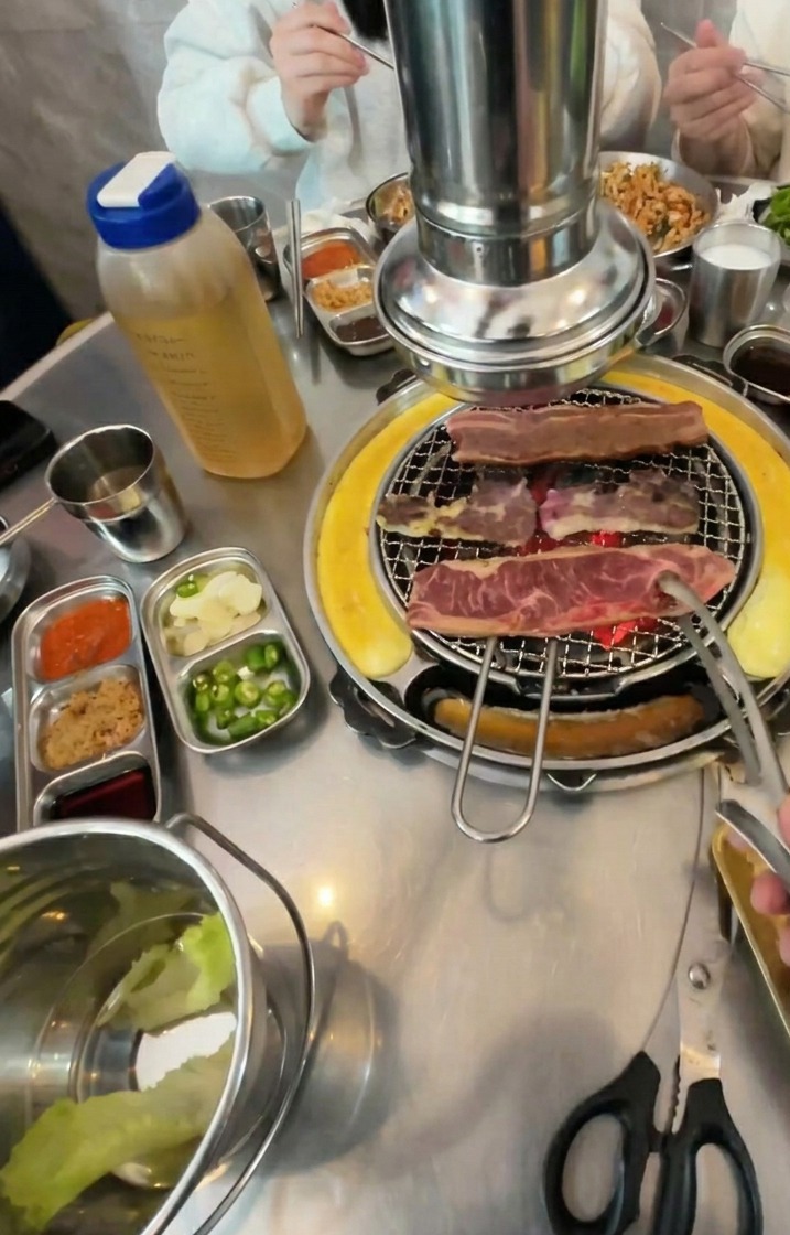 Tiras de ternera dándose la vuelta en la parrilla, mostrando un exterior de color marrón intenso y caramelizado.