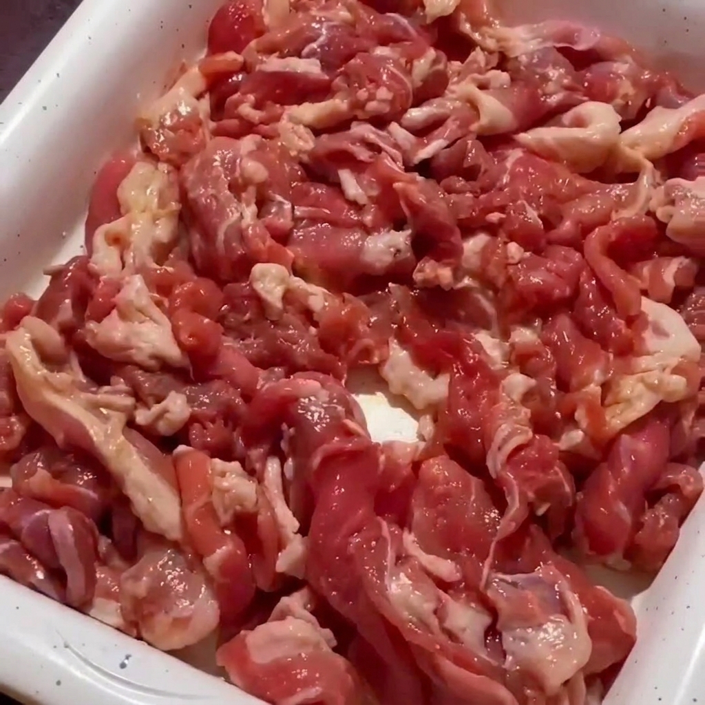 Primer plano de la carne de cerdo salteándose en una sartén hasta que los bordes se doren.