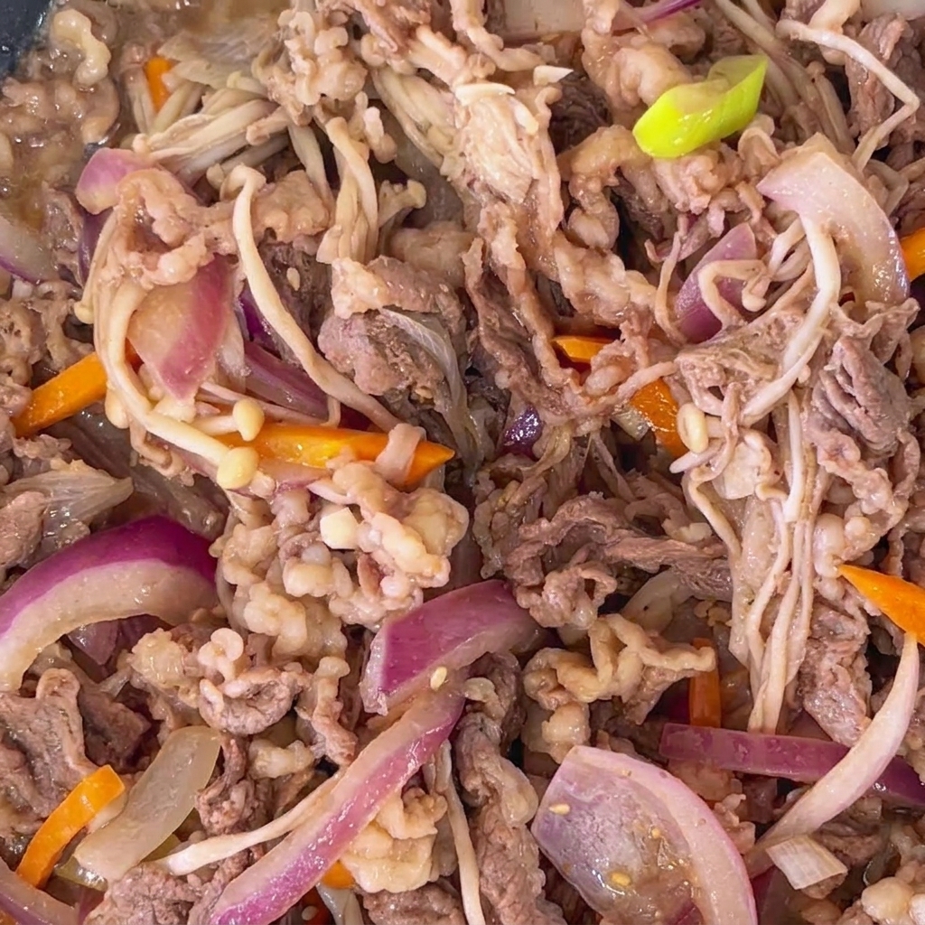 Primer plano de bulgogi de ternera cocinado con semillas de sésamo tostadas esparcidas por todo el plato.