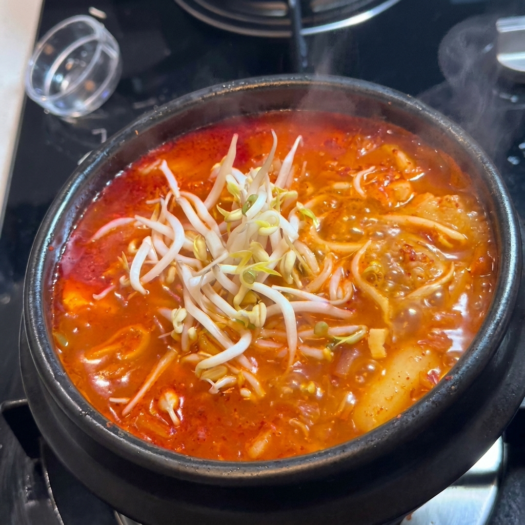 Un montón de brotes de soja frescos sobre la superficie del Kimchi-jjigae.