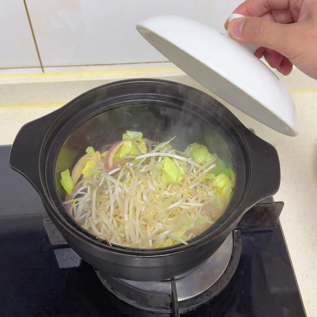 Brotes de soja frescos sobre el repollo cocinado dentro de una olla oscura mientras se levanta la tapa.