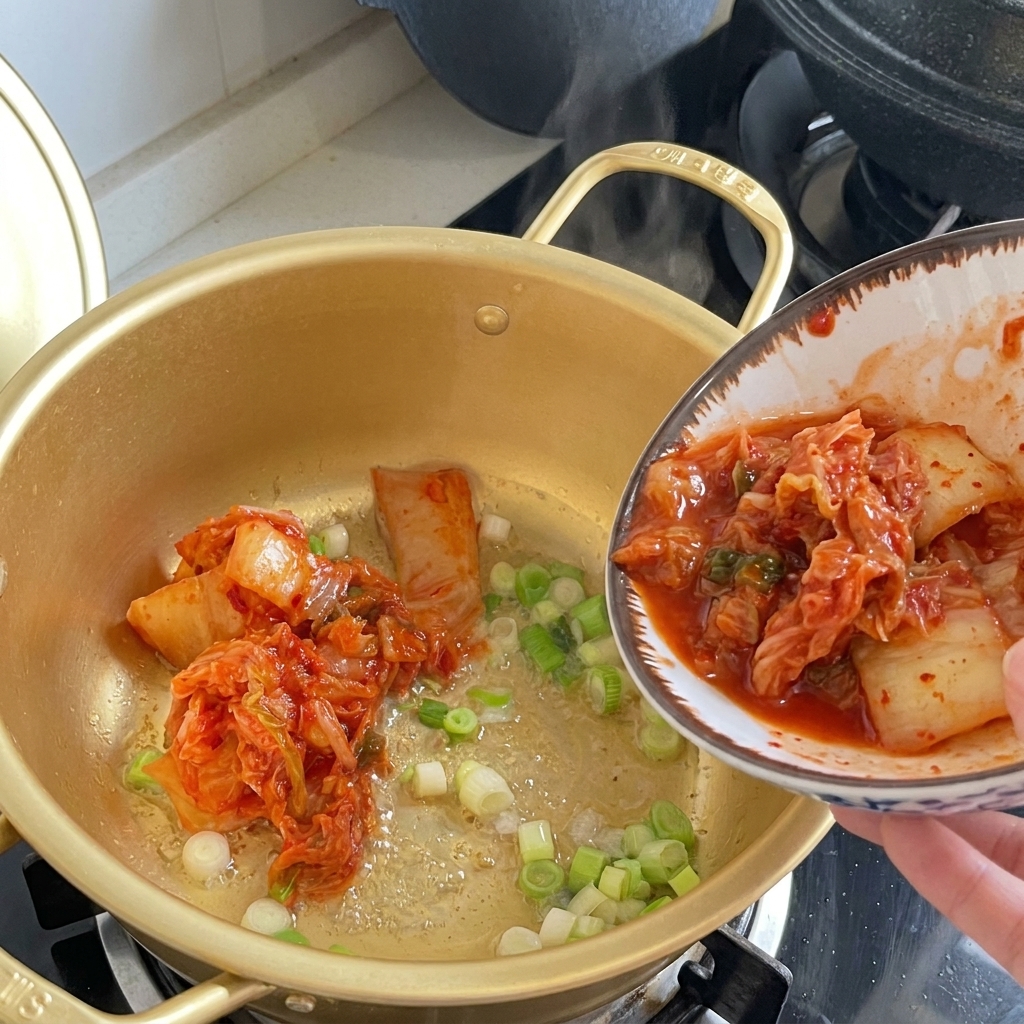 Unas pinzas de madera pasando trozos de kimchi desde un bol blanco a la olla.