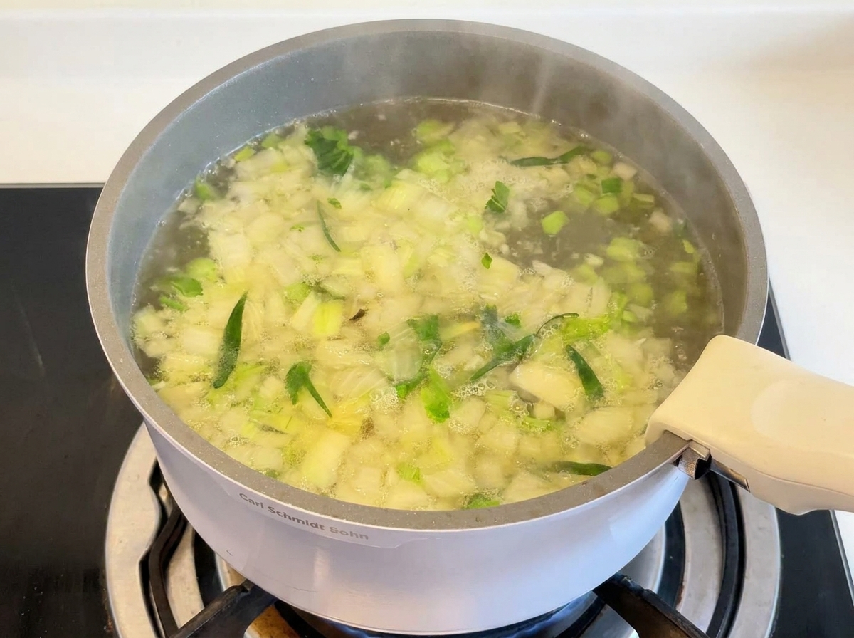 Muslos de pollo y arroz cocinándose a fuego lento en un caldo burbujeante.
